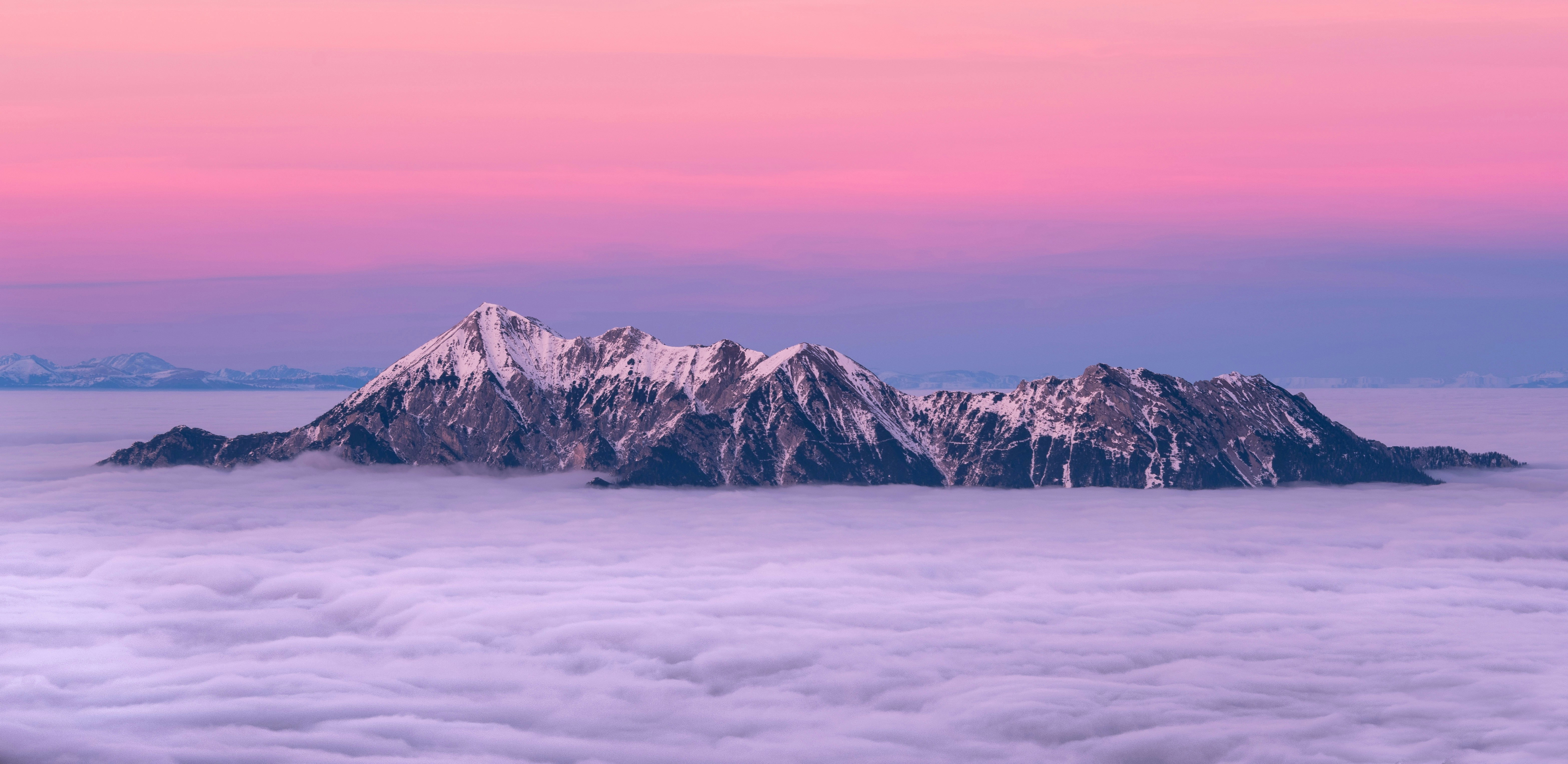 photo of snow-capped mountain surrounded by sea of clouds